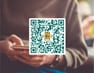 teija-appen – Min Föreningsapp för våra medlemmar QR-kod ovanpå person med mobil – information om teijas medlemsapp Min Föreningsapp